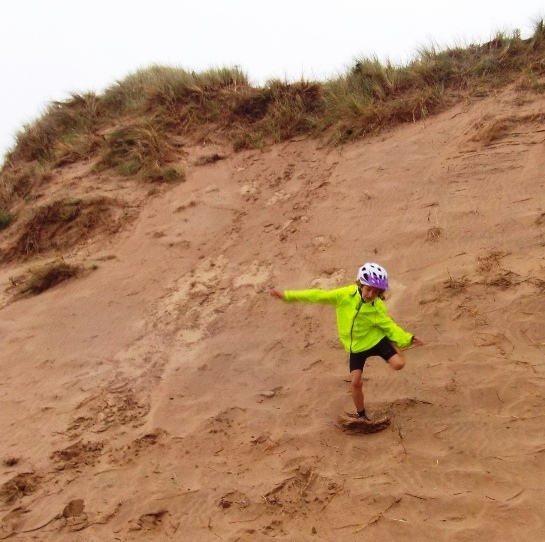 Tati slides down sand dune.